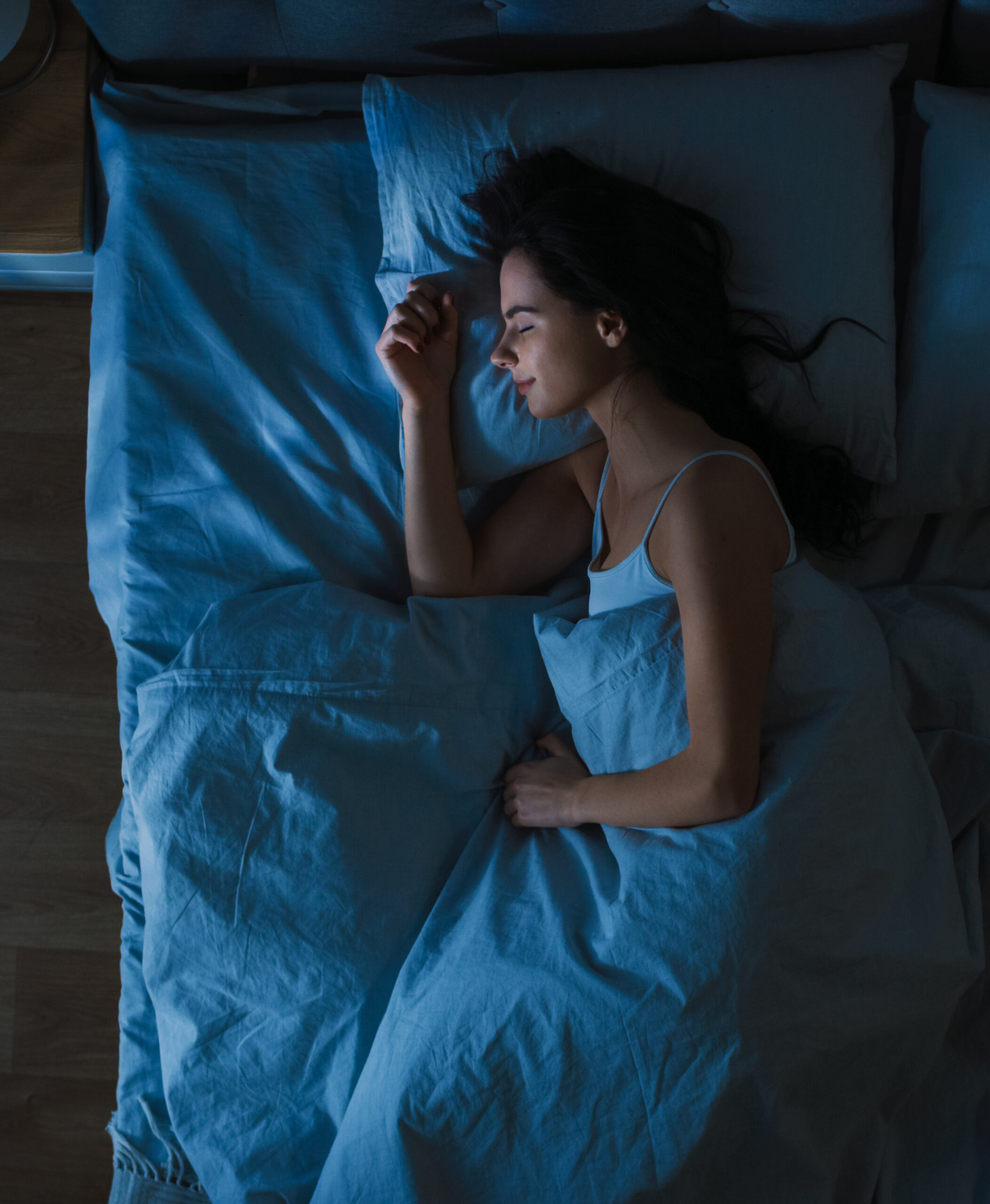 Top View of Beautiful Young Woman Sleeping Cozily on a Bed in Hi Sleep America--woman sleeping in dark room.